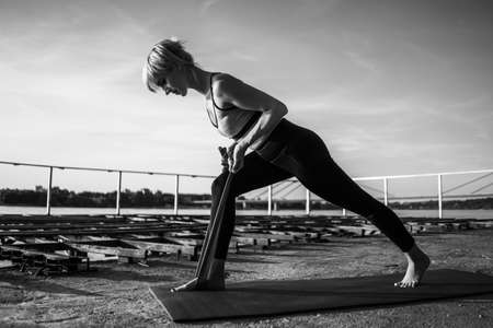 Woman exercising pilates with elastic band on sunny day.の写真素材