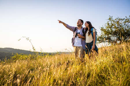 Happy couple is hiking in mountain.の写真素材