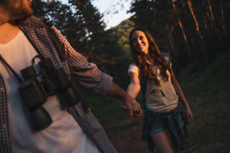 Happy couple is hiking in forest.