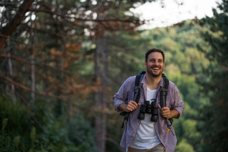 Happy adult man is hiking in forest.の写真素材