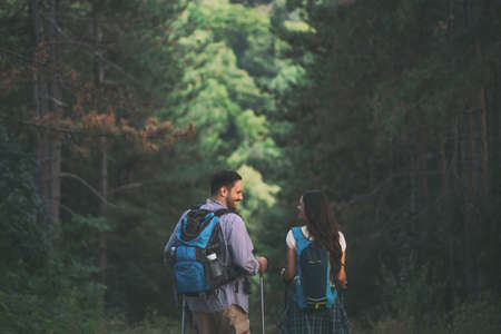 Happy couple is hiking in forest.の写真素材