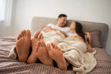 Happy couple is enjoying and relaxing themselves in bed.