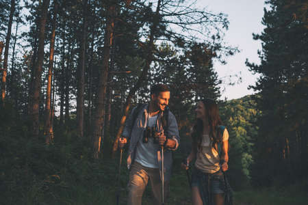 Happy couple is hiking in forest.の写真素材