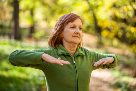 Senior woman is exercising in park on sunny day.の写真素材