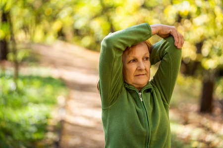 Senior woman is exercising in park on sunny day.の写真素材