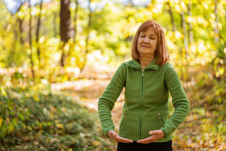 Senior woman is practicing Tai Chi exercise in park.の写真素材