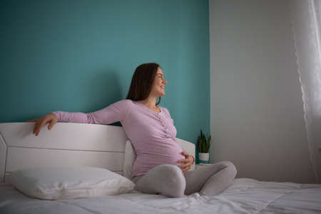 Happy pregnant woman relaxing at home.の写真素材