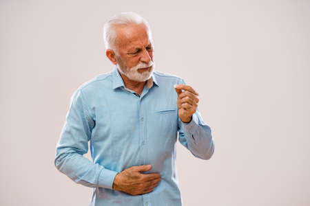 Portrait of senior man who is having pain in stomach.の写真素材