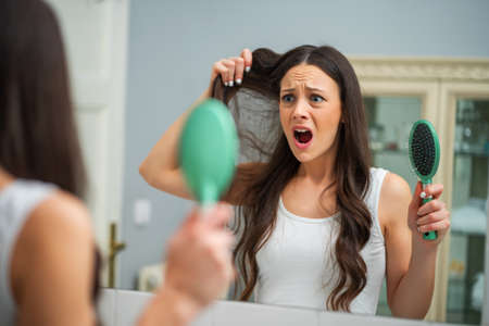 Young woman is in panic because of hair loss.の写真素材