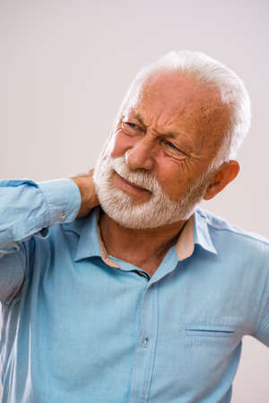 Portrait of senior man who is having pain in neck.の写真素材