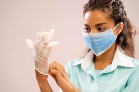 Portrait of young nurse wearing medical mask and gloves.の写真素材