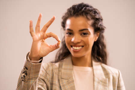 Studio shot portrait of beautiful happy african-american ethnicity businesswoman. Selective focus on hand.の写真素材