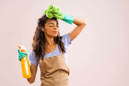 Portrait of african-american professional maid who is tired of cleaning.