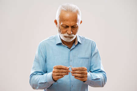 Portrait of serious senior man who is decided to quit smoking.の写真素材