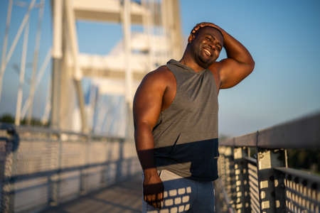 Young african-american man is exercising on the bridge in the city.の写真素材
