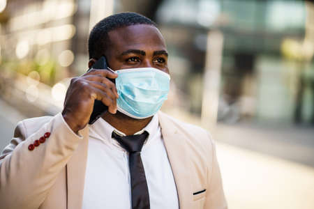Portrait of responsible businessman who is wearing protective mask. Covid-19 virus pandemic concept.の写真素材