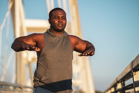 Portrait of young african-american man in sports clothing who is exercising to reduce his body weight.の写真素材