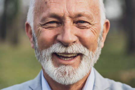 Close up portrait of happy senior man. Elderly man is smiling and looking at camera.の写真素材