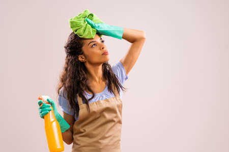Portrait of african-american professional maid who is tired of cleaning.の写真素材