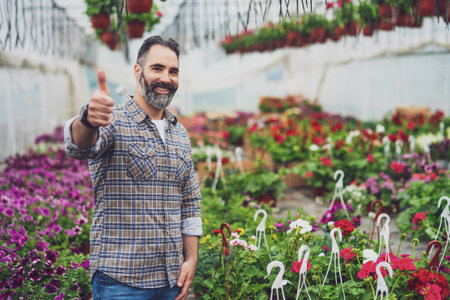Adult man is owning small business greenhouse store.の写真素材