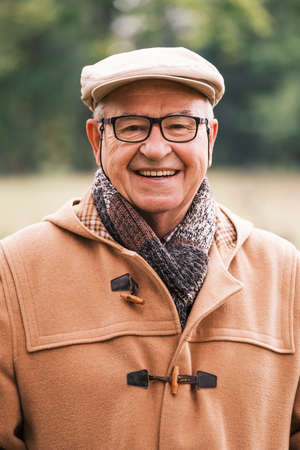 Outdoor portrait of cheerful senior man in winter coat.の写真素材