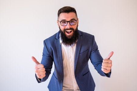 Portrait of happy businessman who is smiling and showing thumbs up. Copy space on image for your text or advert.の写真素材