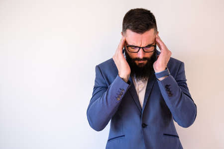 Portrait of businessman who is having headache. Copy space on image for your text or advert.の写真素材