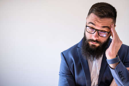 Portrait of businessman who is having headache. Copy space on image for your text or advert.の写真素材