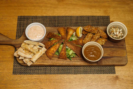 Close up image of served baba ghanoush meal on wooden board.