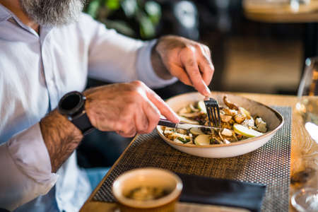 Close up of adult man who is having dinner at restaurant.