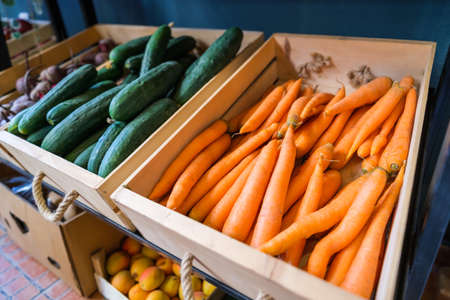 Healthy fruit and vegetables in grocery shop. Close up of basket with carrots in supermarket.
