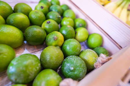 Close up of basket with lime fruit in supermarket.の写真素材