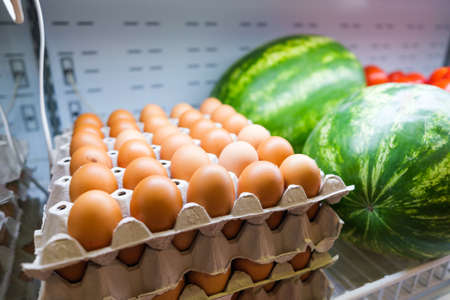 Healthy fruit and vegetables in grocery shop. Close up of basket with eggs in refrigerator.の写真素材