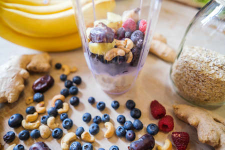 Healthy fruit shake on table with fruits and vegetables ingredients around.の写真素材