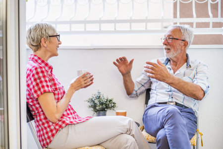 Senior couple sitting and talking on terrace at their home. Leisure time.の写真素材