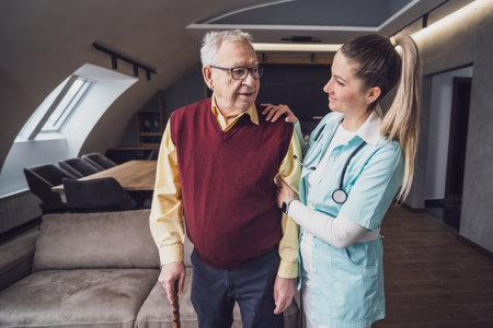 Senior man with walking stick and nurse in nursing home, healthcare conceptの写真素材