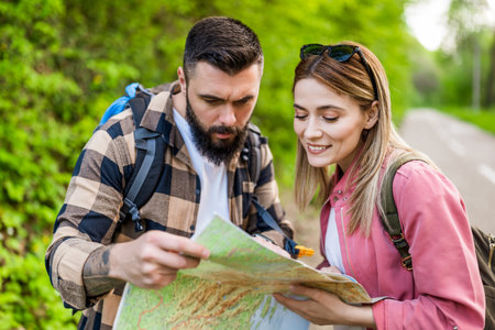 Happy couple hiking in nature and looking at map. Couple enjoying their vacation.の写真素材