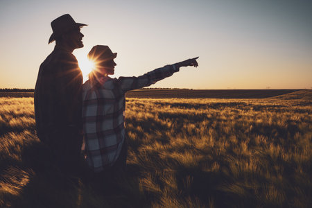 Man and woman are standing in their agricultural field. They are cultivating barley.の写真素材