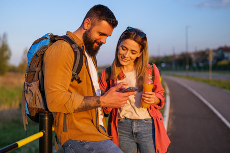 Happy smiling couple using smartphone in the city.の写真素材