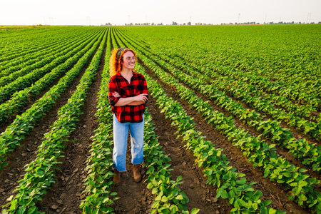 Portrait of female farmer who is cultivating soybean. She is satisfied with good progress of plants. Agricultural occupation.の写真素材