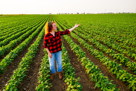 Portrait of female farmer who is cultivating soybean. She is satisfied with good progress of plants. Agricultural occupation.の写真素材