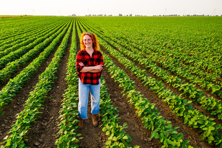 Portrait of female farmer who is cultivating soybean. She is satisfied with good progress of plants. Agricultural occupation.の写真素材