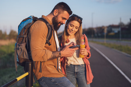 Happy smiling couple using smartphone in the city.の写真素材