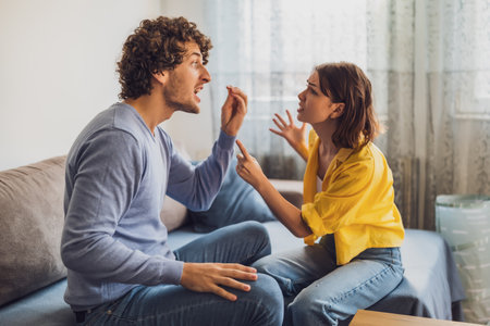 Man and woman are sitting at sofa and arguing. Relationship problems.の写真素材