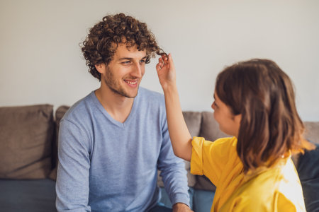 Portrait of young happy couple in love. Woman is playing with man's curly hair.の写真素材