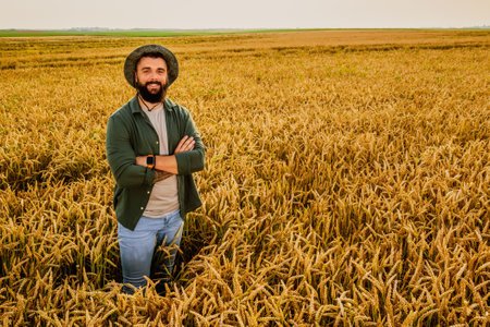 Portrait of farmer who is cultivating wheat. He is satisfied with good progress of plants. Agricultural occupation.の写真素材