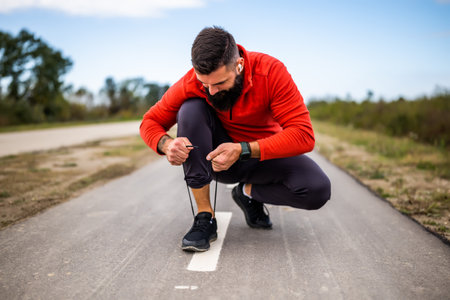 Young man is tying a shoelace before jogging.の写真素材