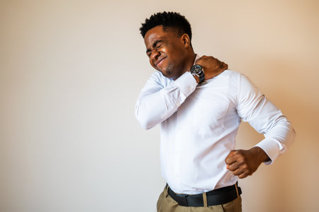 Portrait of young businessman who is having pain in his back. Copy space on image for your text or advert.の写真素材