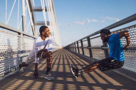 African american man and Caucasian woman doing exercise on the bridge.の写真素材