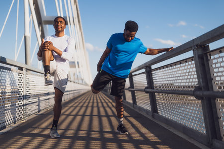 african american and caucasian men jogging on bridge